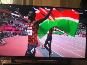 Members watching a Kenyan athlete celebrate on TV
